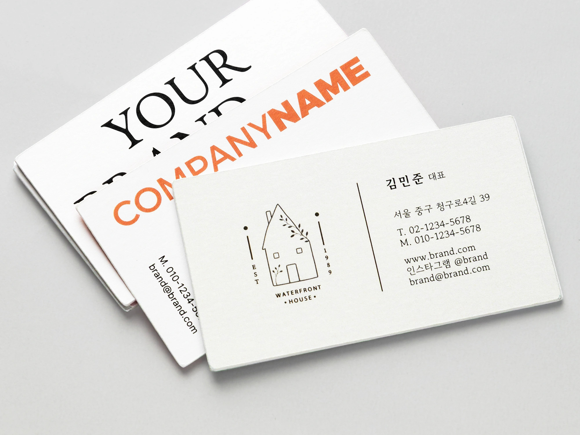 검정과 주황색으로 인쇄한 명함 세 장을 겹쳐 놓은 사진