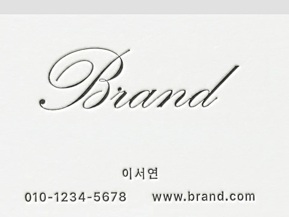 필기체 Brand 로고가 종이에 깊게 눌려 인쇄된 레터프레스 명함 접사